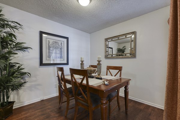 Dining area featuring modern furnishings and large windows at Landera Apartments