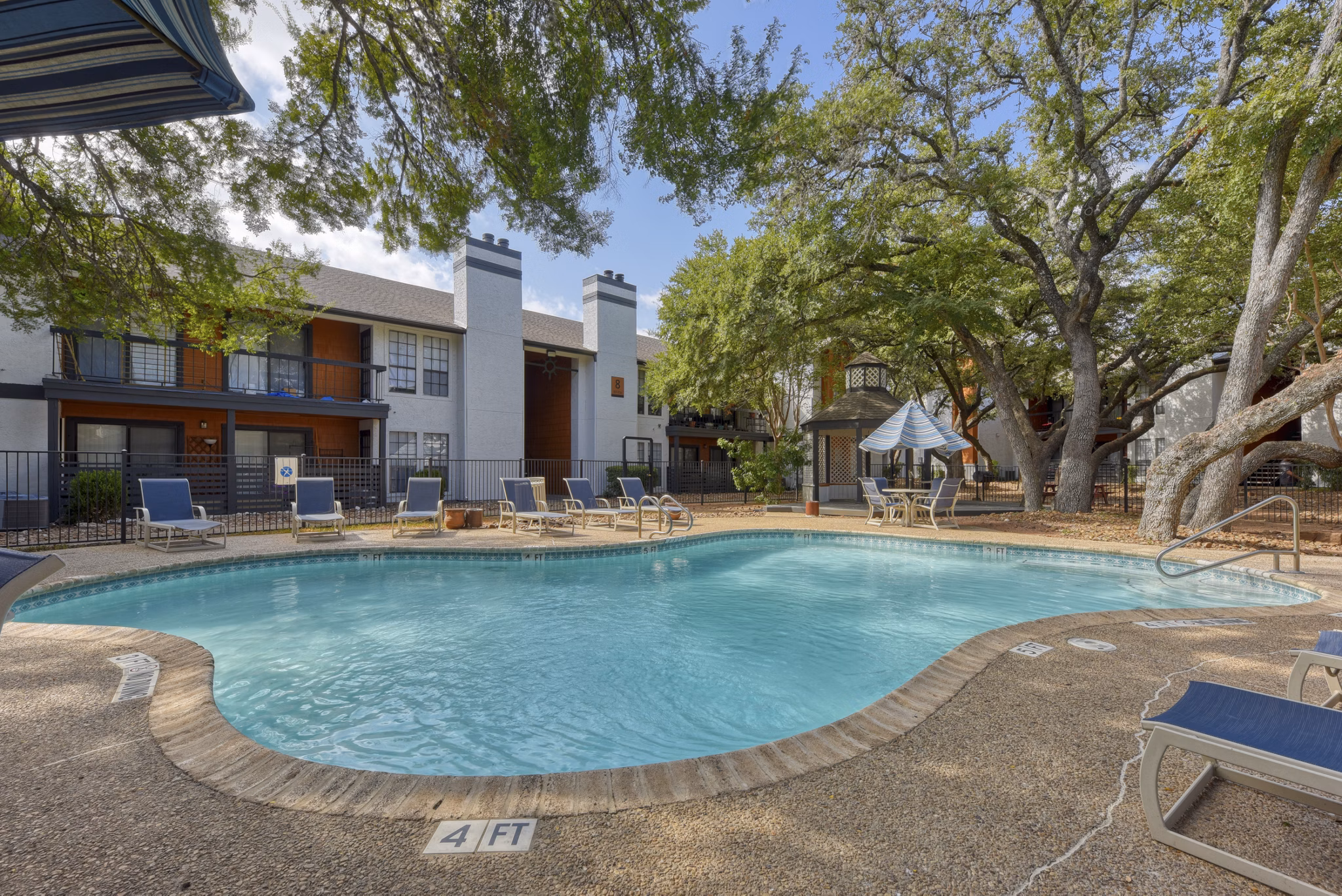 Relaxing outdoor pool area with lounge chairs at Landera Apartments, perfect for unwinding in a luxury setting