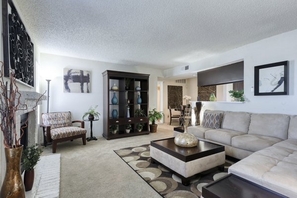 Living room featuring modern furniture and bright lighting at Broadstone Medical Apartments