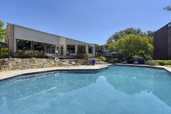 Relaxing poolside area at Broadstone Medical Apartments with lounge chairs and lush landscaping