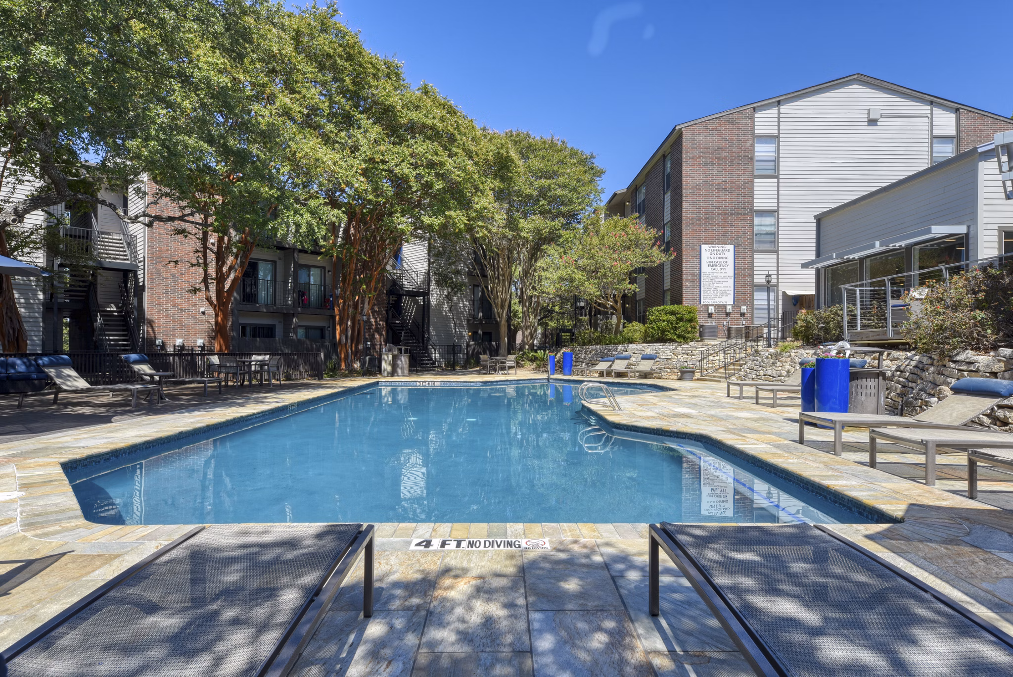 Resort-style pool with sun loungers at Broadstone Medical Apartments, ideal for relaxation and leisure