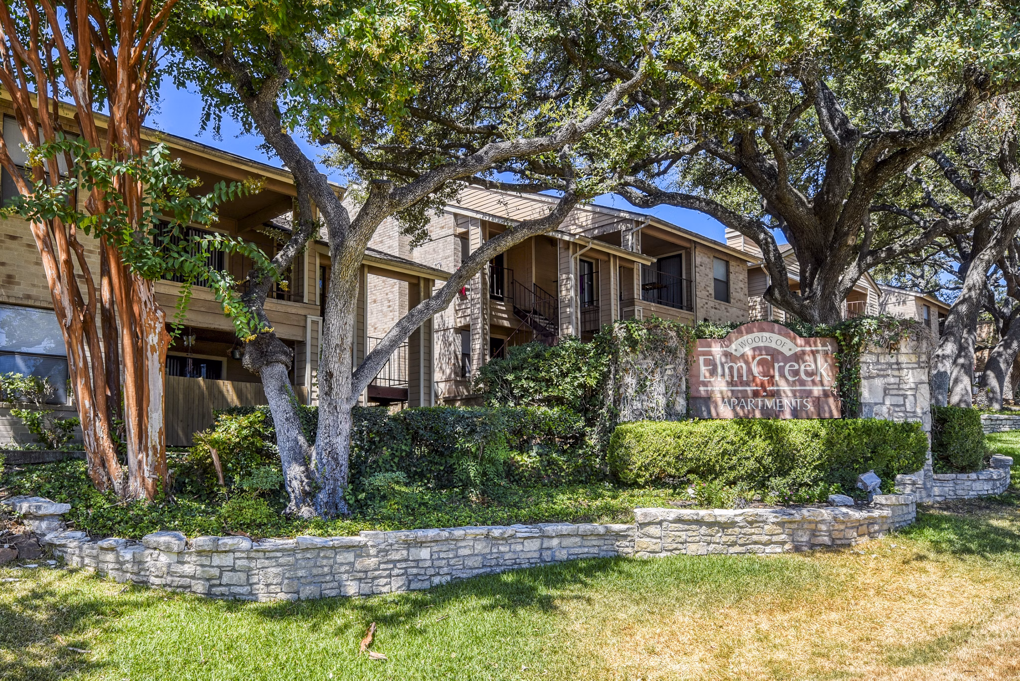 Woods of Elm Creek: Classic brick with distinctive signage in a tranquil San Antonio location Luxury living defined