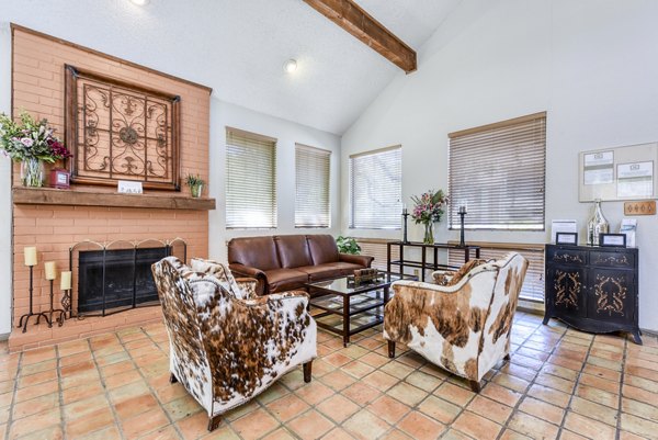 Clubhouse lobby with modern seating and lighting at Woods of Elm Creek Apartments, creating a welcoming community space