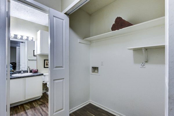 Convenient laundry room with washing machine hookups at Woods of Elm Creek Apartments, offering modern amenities for residents