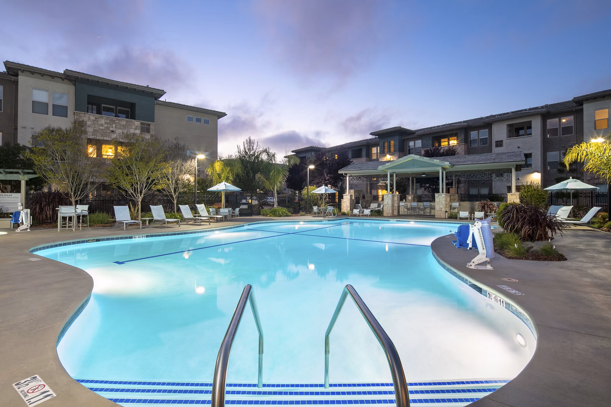 Resort-style pool surrounded by lush landscaping at Fiori Estates Apartments, offering luxury living in a serene setting