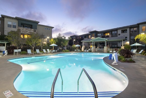 Resort-style pool surrounded by lush landscaping at Fiori Estates Apartments, offering luxury living in a serene setting