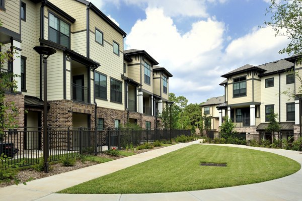 Serene courtyard with lush greenery at The Townhomes at Woodmill Creek, offering a tranquil retreat in a luxury apartment community
