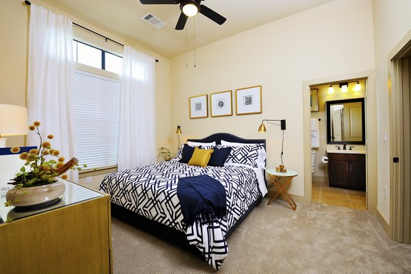 Cozy bedroom with modern decor and large window at The Townhomes at Woodmill Creek