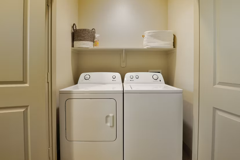 Laundry room with energy-efficient washers and dryers in The Townhomes at Woodmill Creek