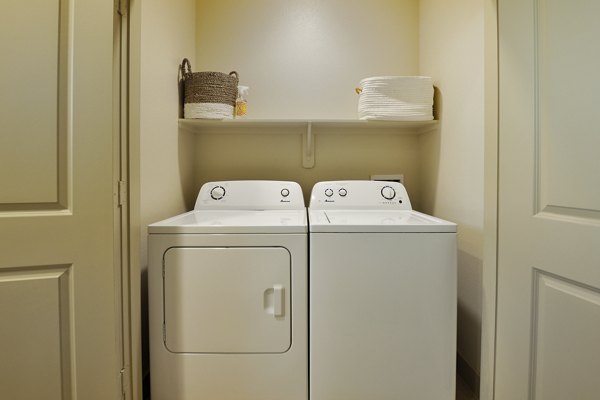Laundry room with energy-efficient washers and dryers in The Townhomes at Woodmill Creek