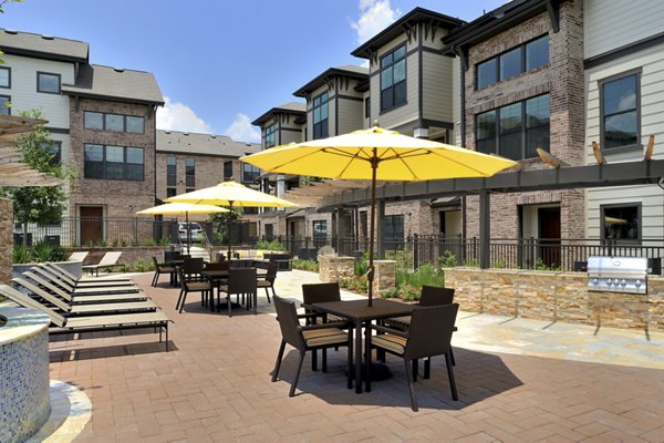 Resort-style pool with lounging chairs at The Townhomes at Woodmill Creek, offering a serene outdoor retreat for residents