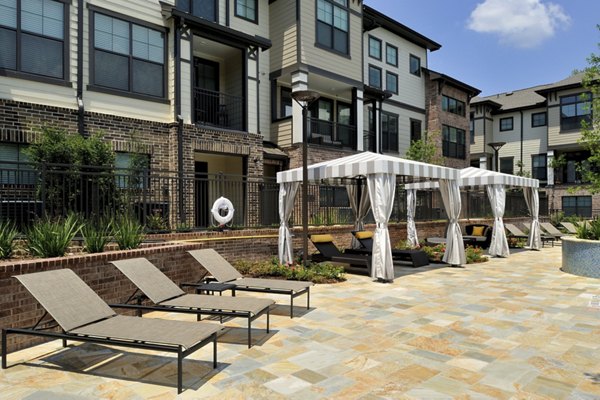 Peaceful poolside at The Townhomes at Woodmill Creek, offering luxury relaxation in a serene environment perfect for unwinding