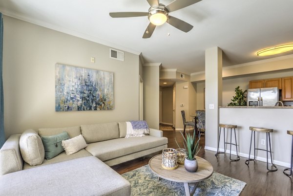 Living room with modern furnishings and natural light at Stone Canyon Apartments, a luxury property by Greystar