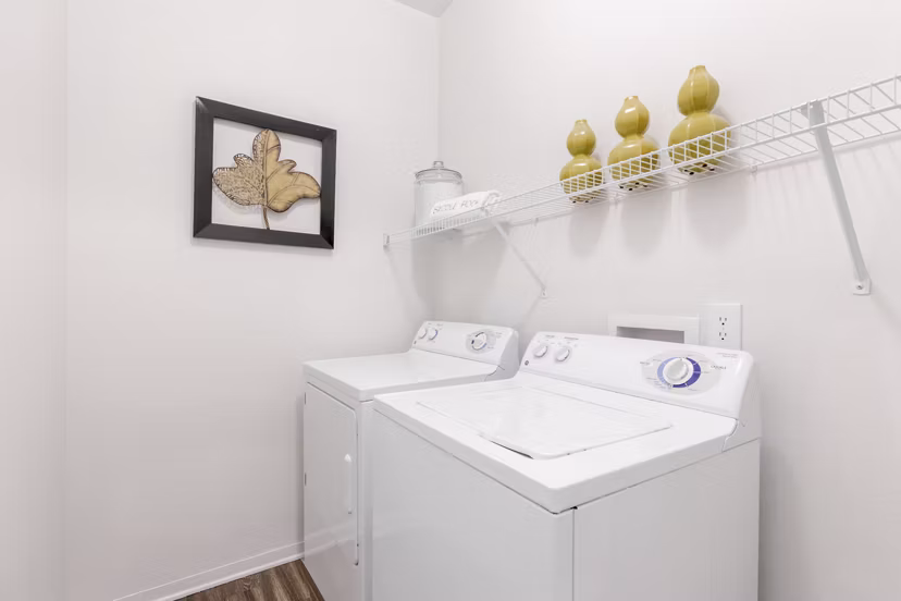 Laundry room with modern appliances at Canyons at Saddle Rock Apartments, a Greystar luxury living community