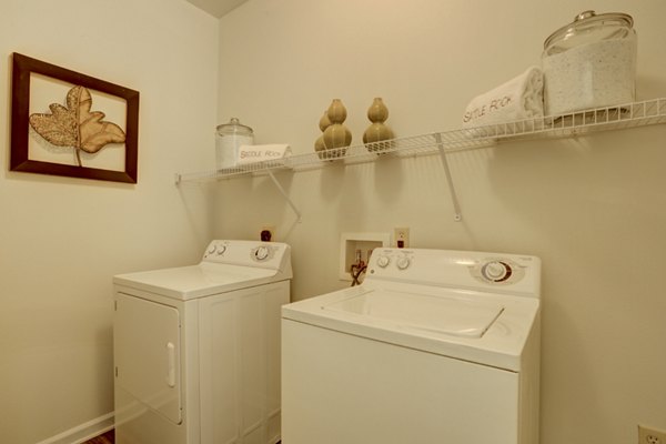 Laundry room with modern appliances at Canyons at Saddle Rock Apartments, a Greystar luxury living community