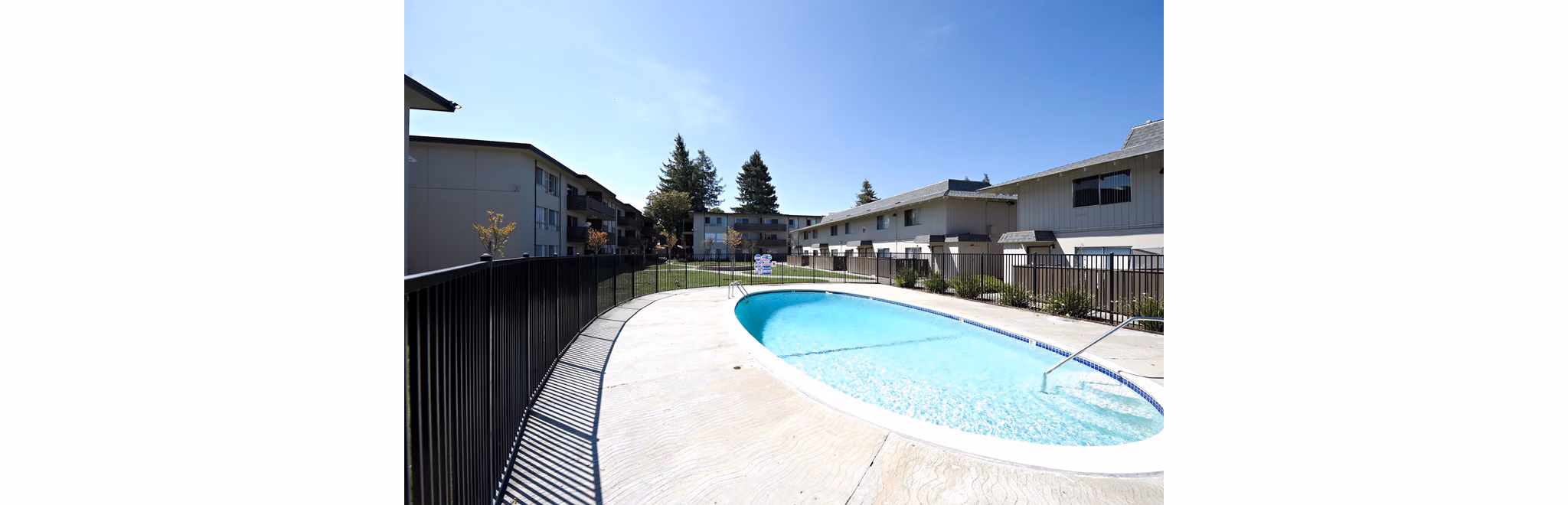 Resort-style pool with sun loungers at Woodland Park Apartments, offering luxury living and leisure amenities