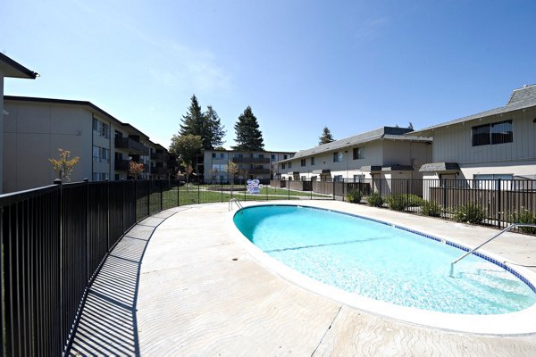 Resort-style pool with sun loungers at Woodland Park Apartments, offering luxury living and leisure amenities