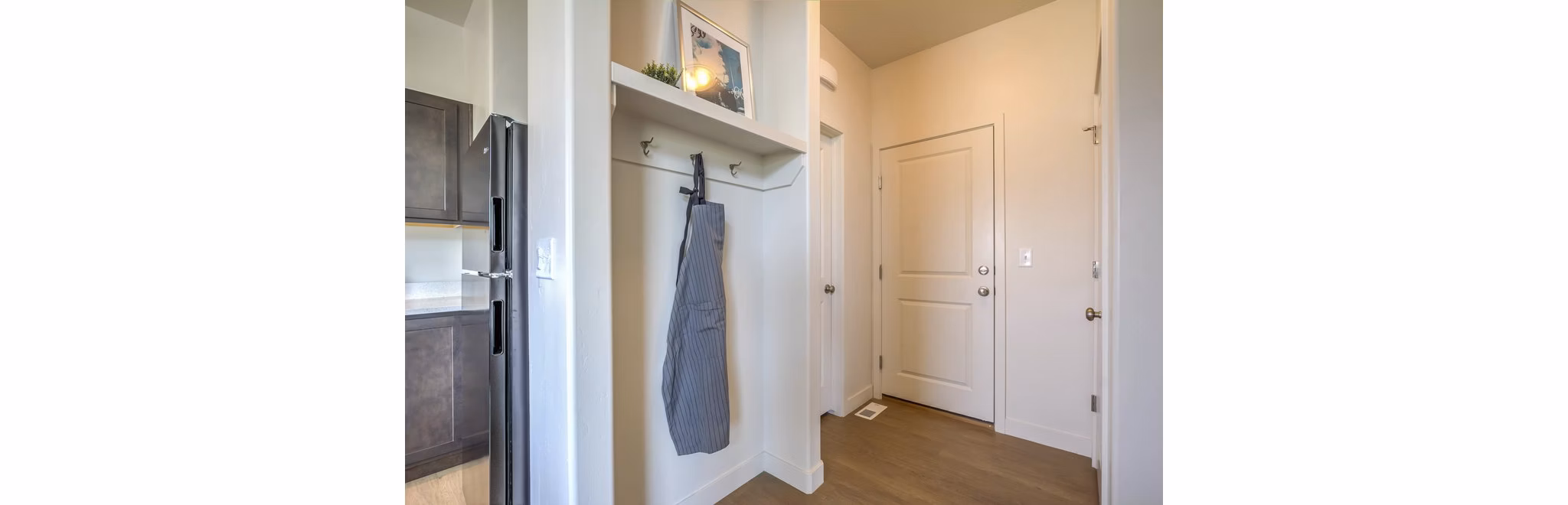 Hallway with modern lighting and hardwood floors in Rockwell Village Apartments