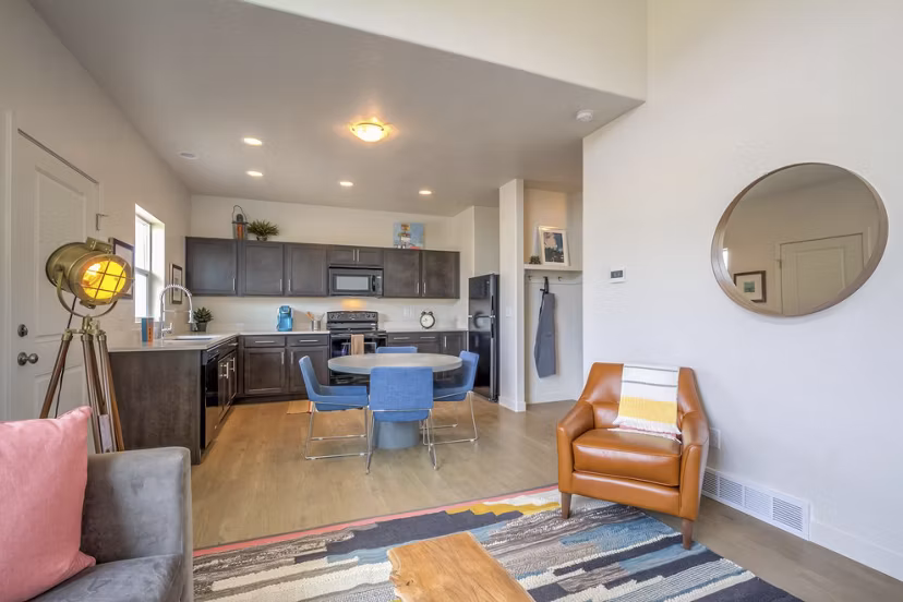 Spacious living room with modern decor and natural light in Rockwell Village Apartments, luxury living at Greystar-managed community