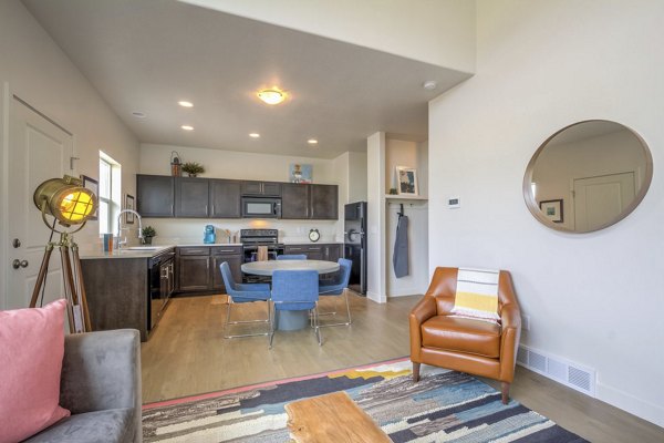 Spacious living room with modern decor and natural light in Rockwell Village Apartments, luxury living at Greystar-managed community