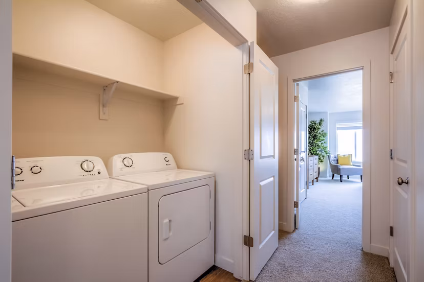 Laundry room with high-efficiency washers and dryers at Rockwell Village Apartments