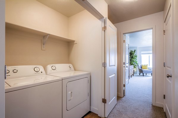 Laundry room with high-efficiency washers and dryers at Rockwell Village Apartments