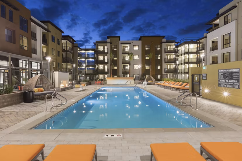 Modern outdoor pool with lounge chairs at Naya Apartments, a Greystar luxury community