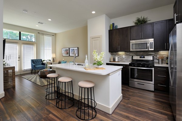 Modern kitchen with granite countertops and stainless steel appliances at Broadstone Woodmill Creek Apartments