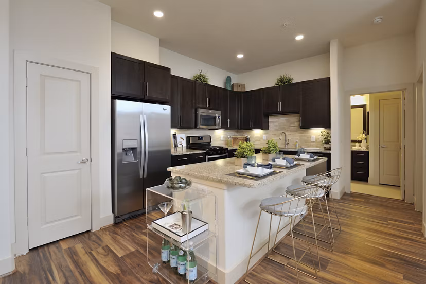 Kitchen featuring modern appliances and granite countertops in Broadstone Woodmill Creek Apartments
