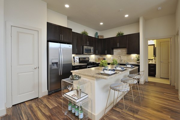 Kitchen featuring modern appliances and granite countertops in Broadstone Woodmill Creek Apartments