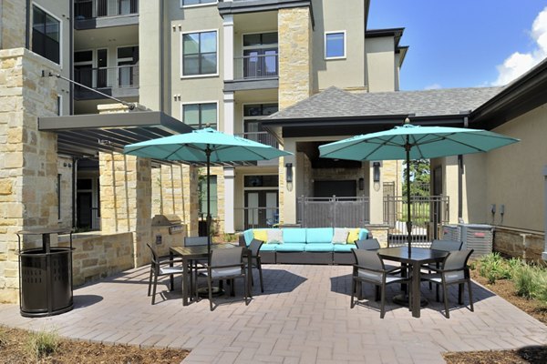 Outdoor grill area with modern seating at Broadstone Woodmill Creek Apartments