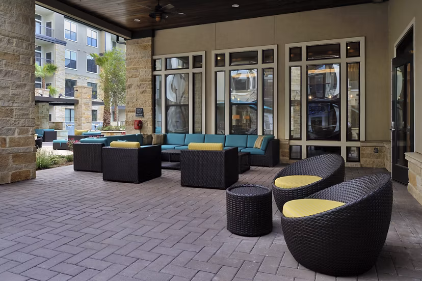Charming patio with cozy seating and lush greenery at Broadstone Woodmill Creek Apartments
