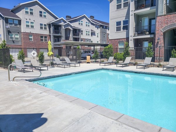 Outdoor swimming pool with lounge chairs at Avanti at Farmington Station Apartments