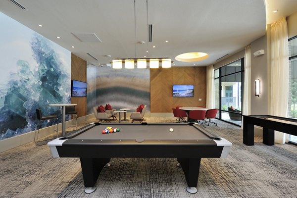 Game room with billiards and lounge seating at Broadstone Energy Park Apartments