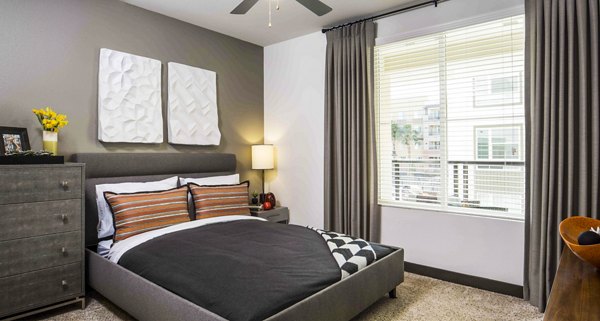 Cozy bedroom with modern furnishings in Jefferson Platinum Triangle Apartments, Anaheim