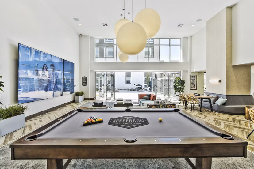 Game room with billiards and gaming consoles at Jefferson Platinum Triangle Apartments, ideal for leisure and entertainment activities