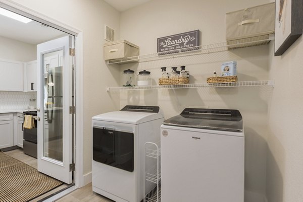 Modern laundry room with stainless steel appliances at Cantera Apartments