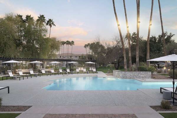 Resort-style pool area at Cantera Apartments with luxury lounge chairs and landscaping
