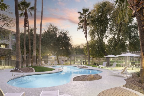 Inviting pool area at Cantera Apartments with lounge chairs and lush landscaping, ideal for relaxation and leisure activities