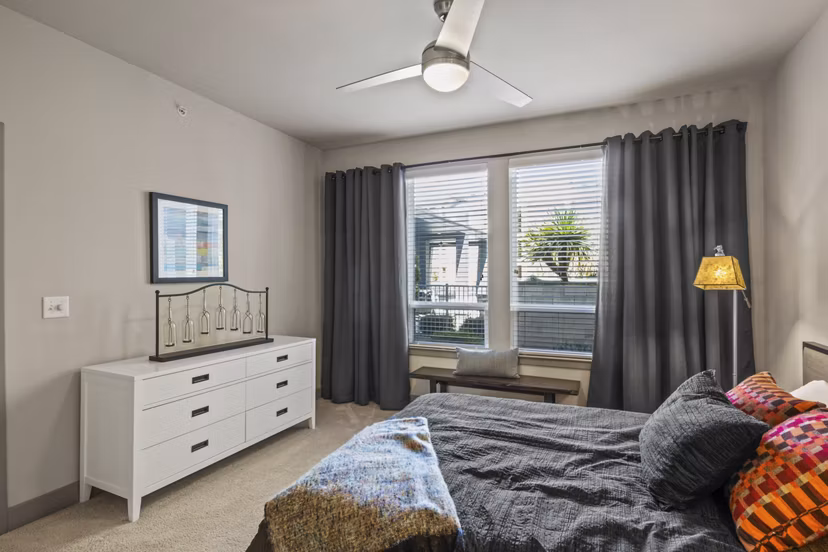 Bedroom featuring modern decor and large windows in Avenue 900 Apartments