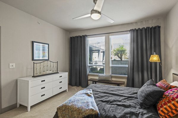 Bedroom featuring modern decor and large windows in Avenue 900 Apartments