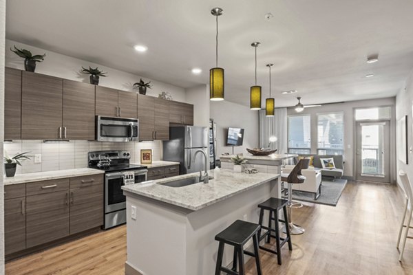 Modern kitchen with sleek appliances and quartz countertops in Avenue 900 Apartments