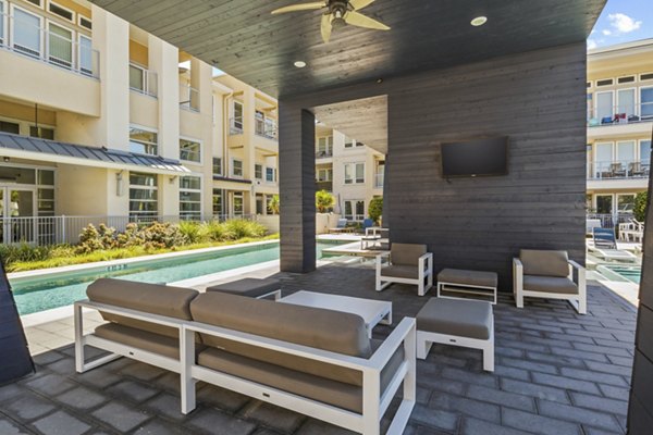 Patio with comfortable seating and string lights at Avenue 900 Apartments, a Greystar community