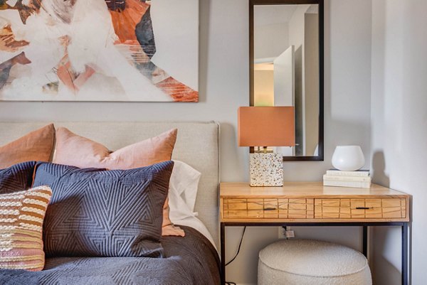 Cozy bedroom with plush bedding at The Essex Apartments, offering luxury living with modern amenities in a prime location