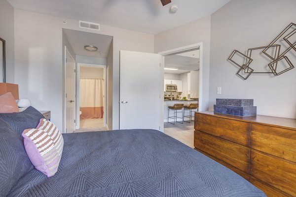 Cozy bedroom with soft lighting at The Essex Apartments, featuring neutral decor and modern furnishings