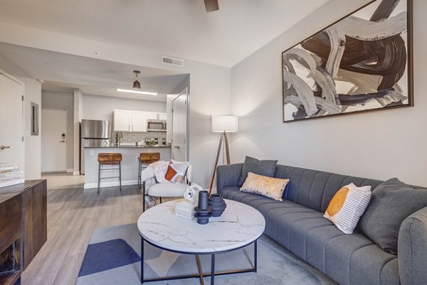 Spacious living room featuring modern decor and natural light in The Essex Apartments