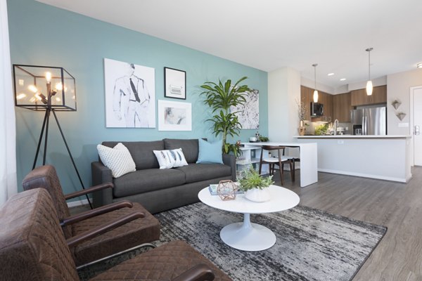 Living room with modern decor and large windows at The Standard Apartments