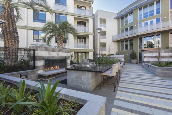 Grill area with modern seating at The Standard Apartments, offering outdoor dining options for residents