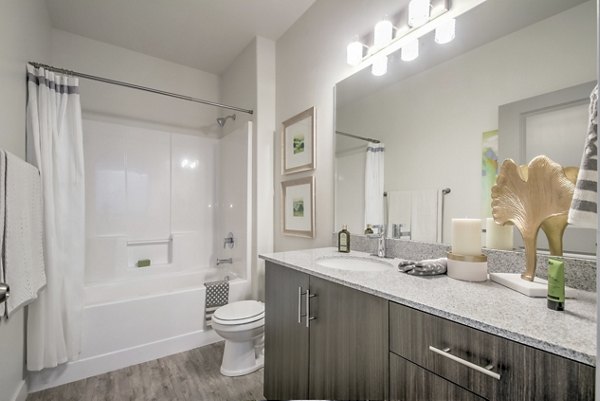 Contemporary bathroom with marble countertops and glass shower in One West Apartments