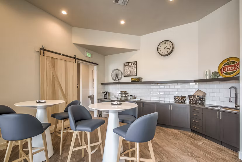 Modern clubhouse featuring cozy seating and a pool table at One West Apartments